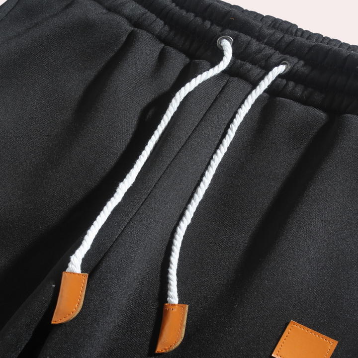 Mænds baggy joggingbukser i marineblå, forfra, med moderne og afslappet pasform.