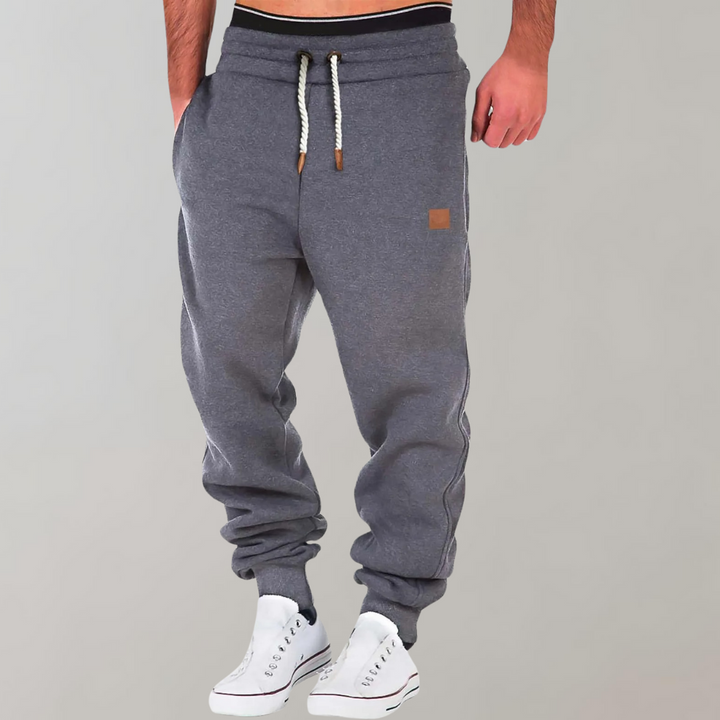 Mænds baggy joggingbukser i marineblå, forfra, med moderne og afslappet pasform.