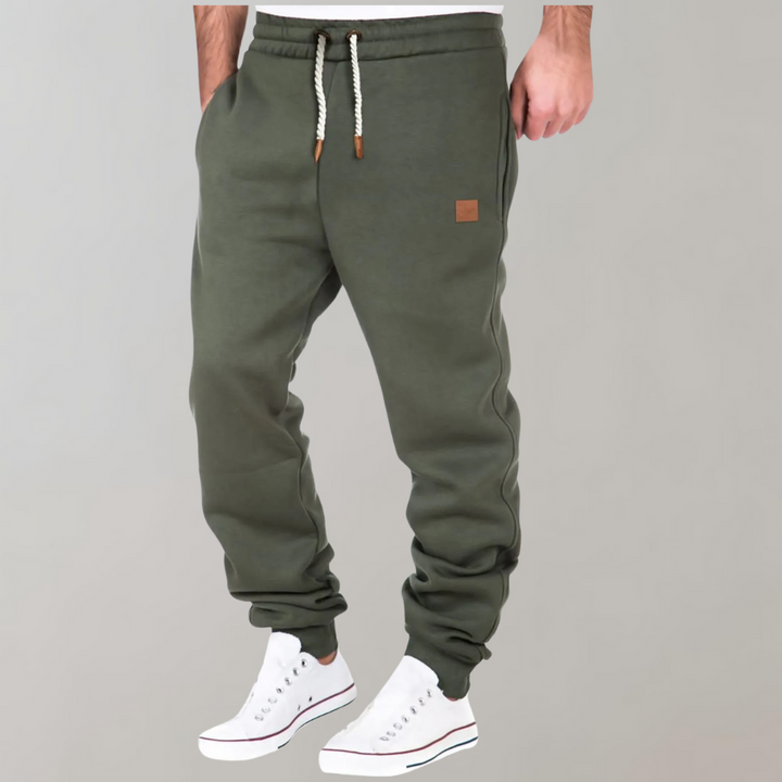 Mænds baggy joggingbukser i marineblå, forfra, med moderne og afslappet pasform.