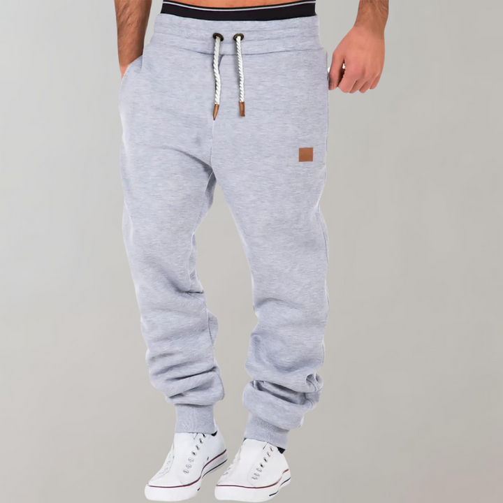 Mænds baggy joggingbukser i marineblå, forfra, med moderne og afslappet pasform.