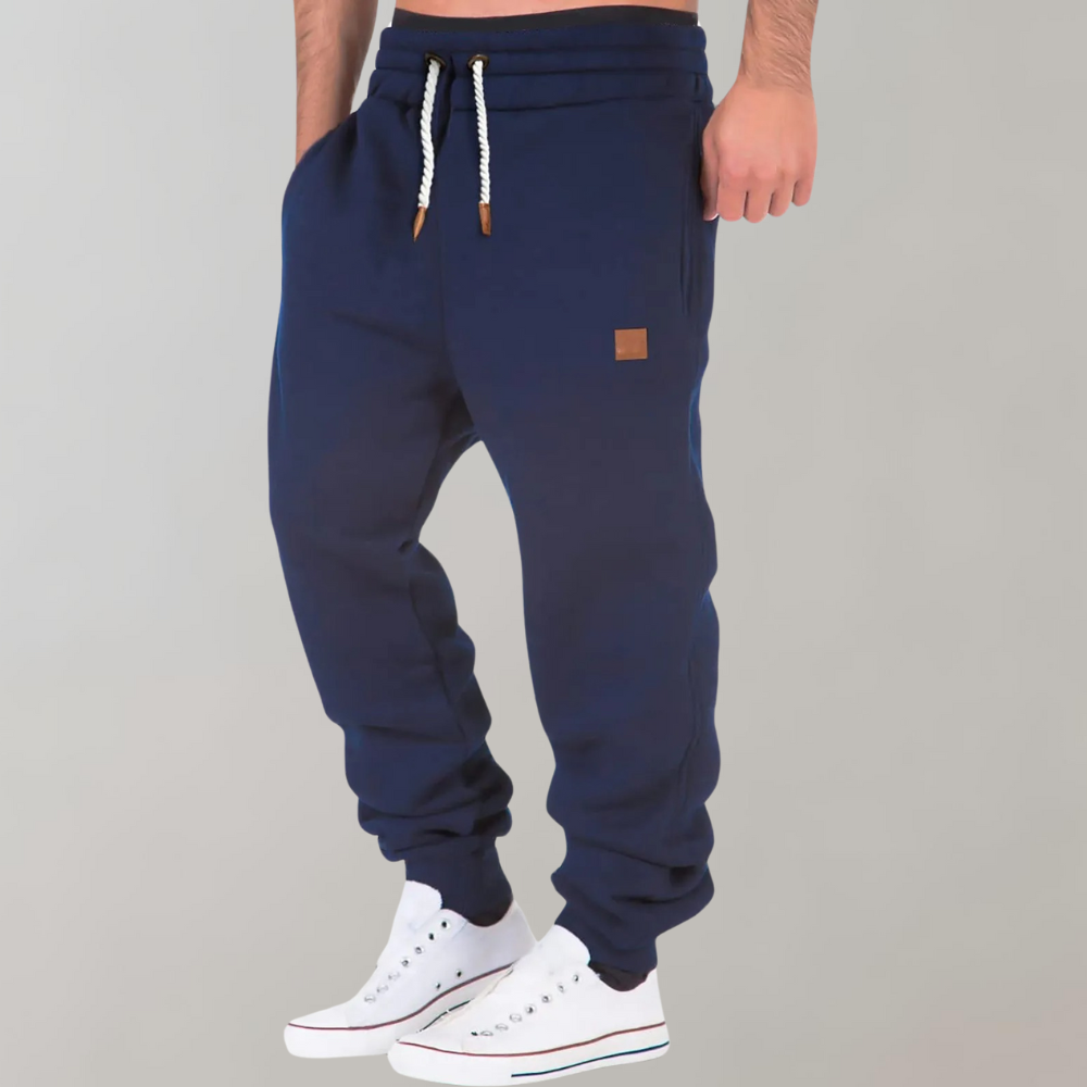 Mænds baggy joggingbukser i marineblå, forfra, med moderne og afslappet pasform.