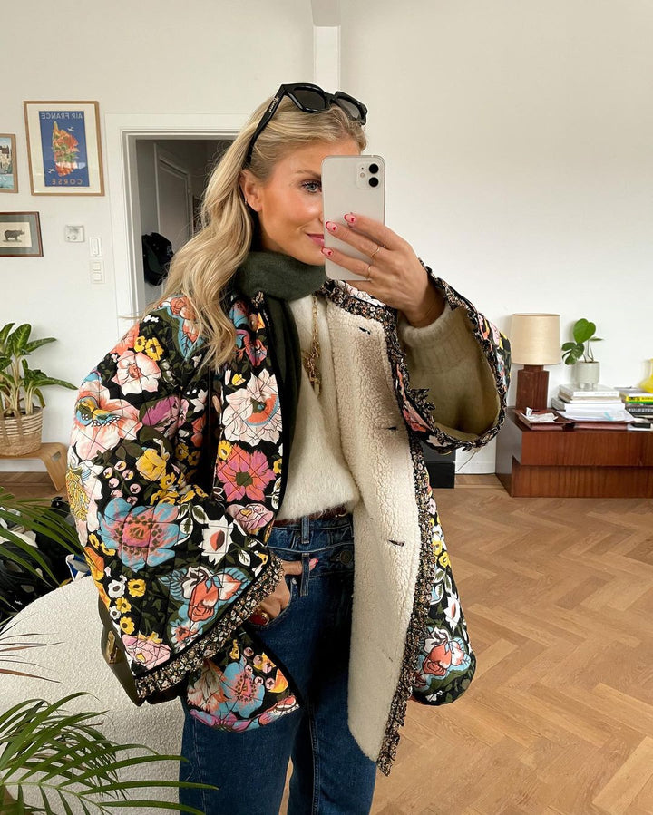 "Blomstret reversibel vinterjakke med boheme design, isolerende foring og brede ærmer for stil og varme."