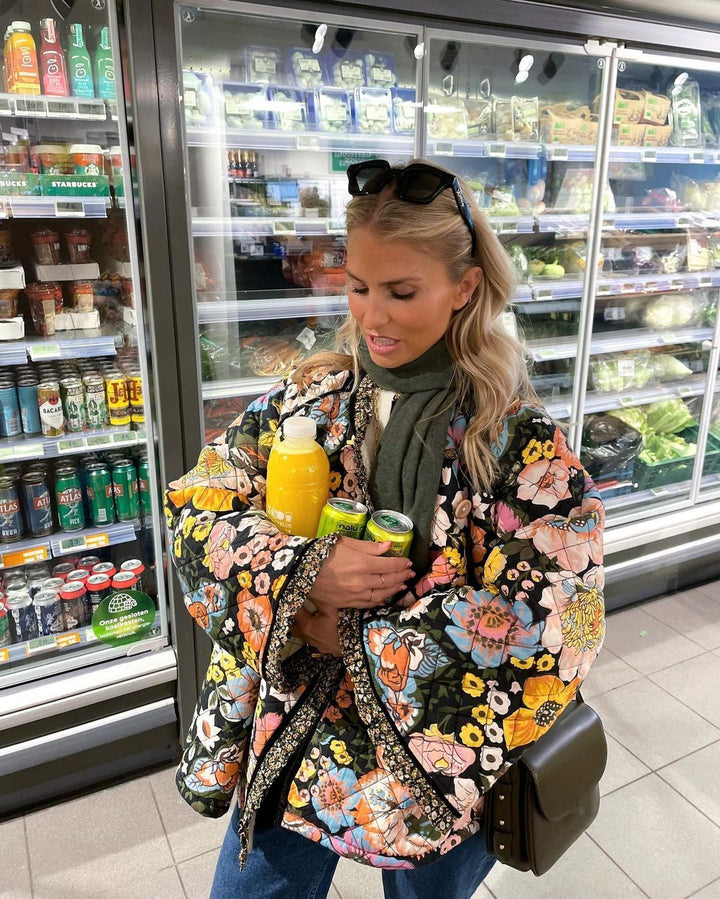 "Blomstret reversibel vinterjakke med boheme design, isolerende foring og brede ærmer for stil og varme."