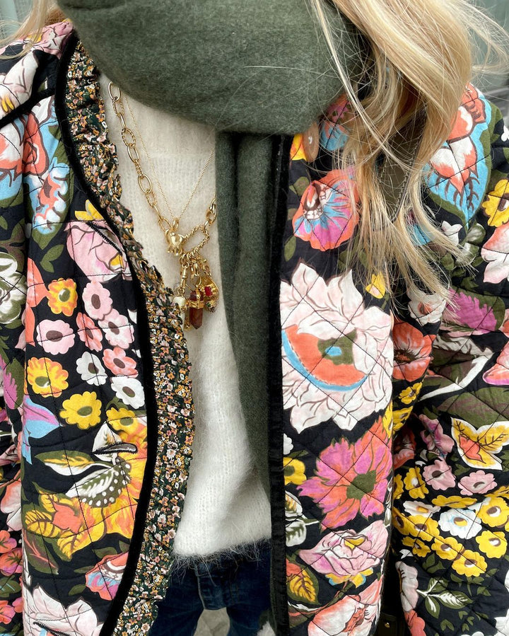 "Blomstret reversibel vinterjakke med boheme design, isolerende foring og brede ærmer for stil og varme."