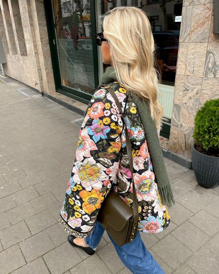 "Blomstret reversibel vinterjakke med boheme design, isolerende foring og brede ærmer for stil og varme."