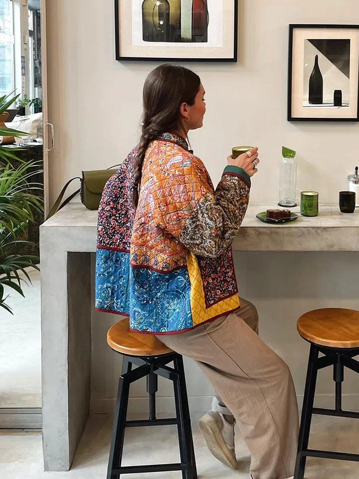 "Blomstret reversibel vinterjakke med boheme design, isolerende foring og brede ærmer for stil og varme."