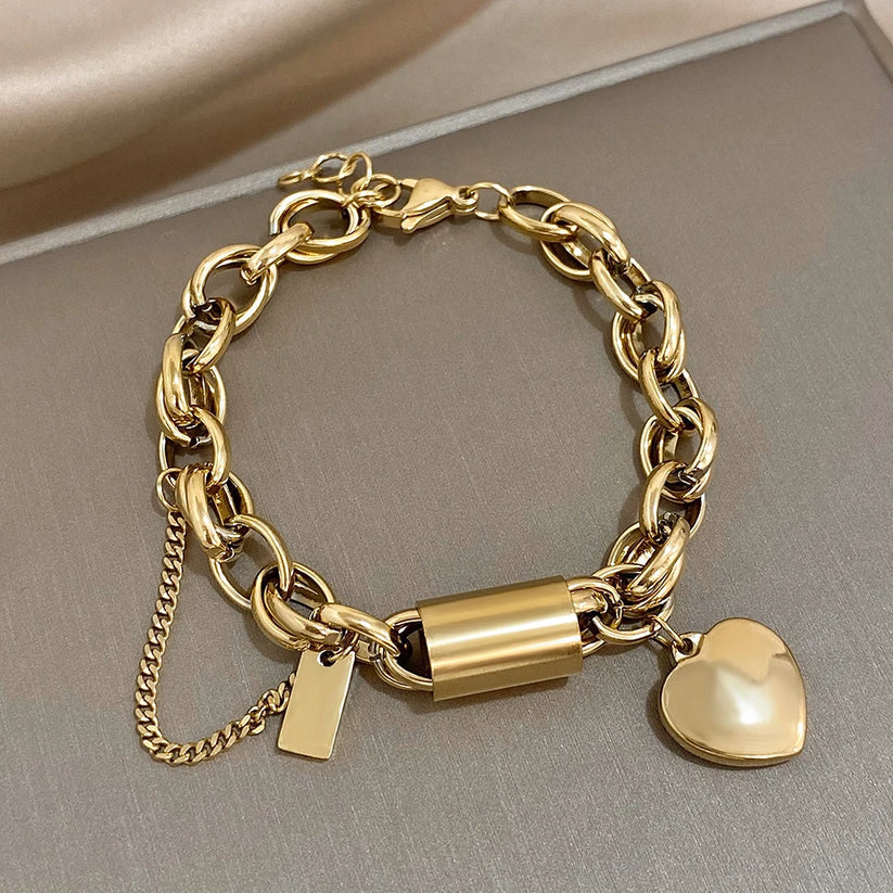 Chunky guld kædearmbånd med skinnende hjertevedhæng. Trendy statement smykke til kvinder, moderne damearmbånd.