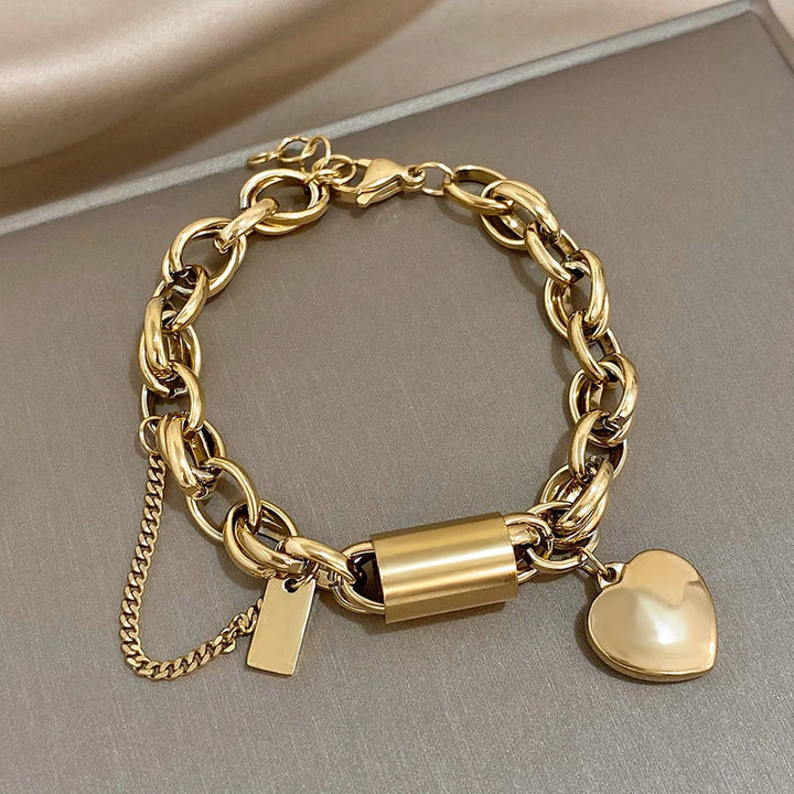 Chunky guld kædearmbånd med skinnende hjertevedhæng. Trendy statement smykke til kvinder, moderne damearmbånd.