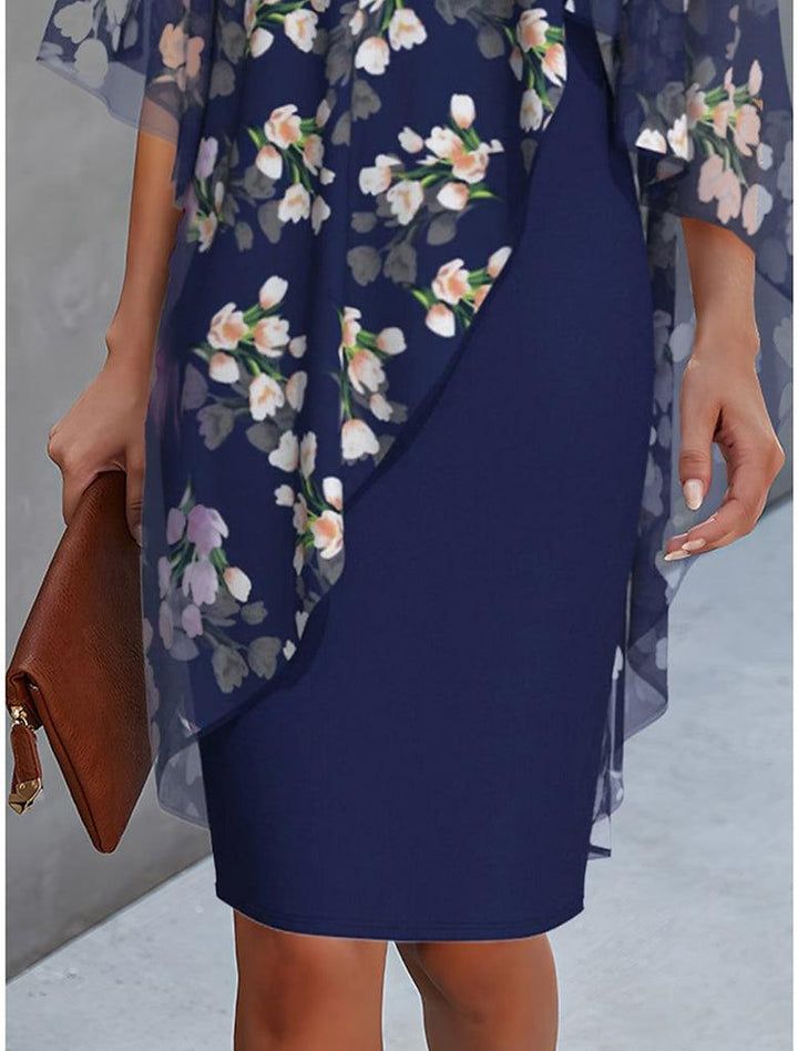 "Cleo floral kjole med blomstermønster og gennemsigtigt lag, asymmetrisk kant for moderne look, feminin elegance."