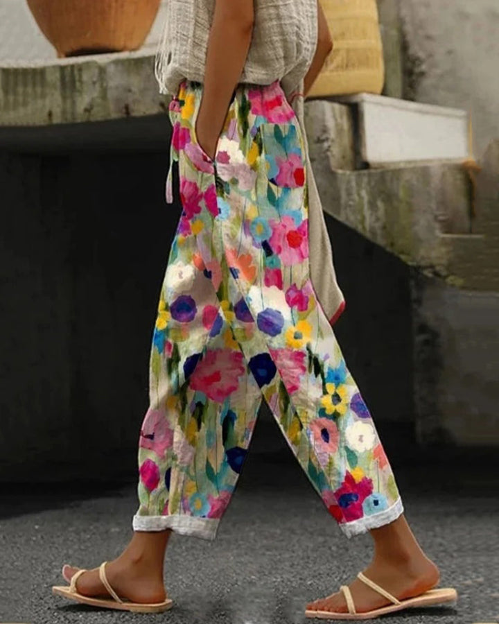 Dame bukser med løs pasform, blomsterprint, brede ben og elastisk talje. Farverig og feminin stil, perfekt til hverdagsbrug.