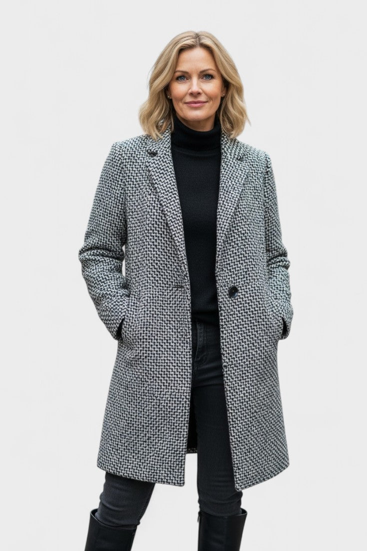 Damefrakke i grå med elegant, struktureret silhuet set fra siden. En tidløs og stilfuld damefrakke.