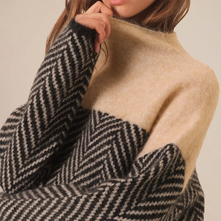 Elegant højhalset damestriktrøje i farveblok design. Varm og moderne sweater til vintergarderoben.