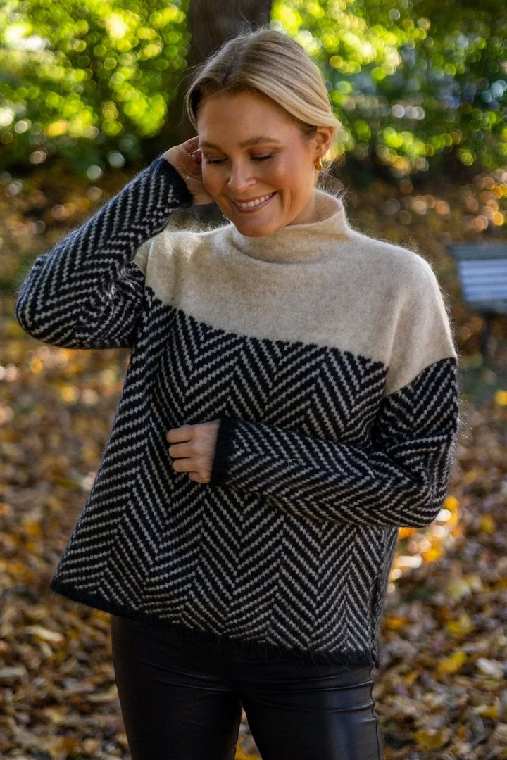 Alsidig damestriktrøje med høj hals og farveblok design. Perfekt til både casual og elegant stil.