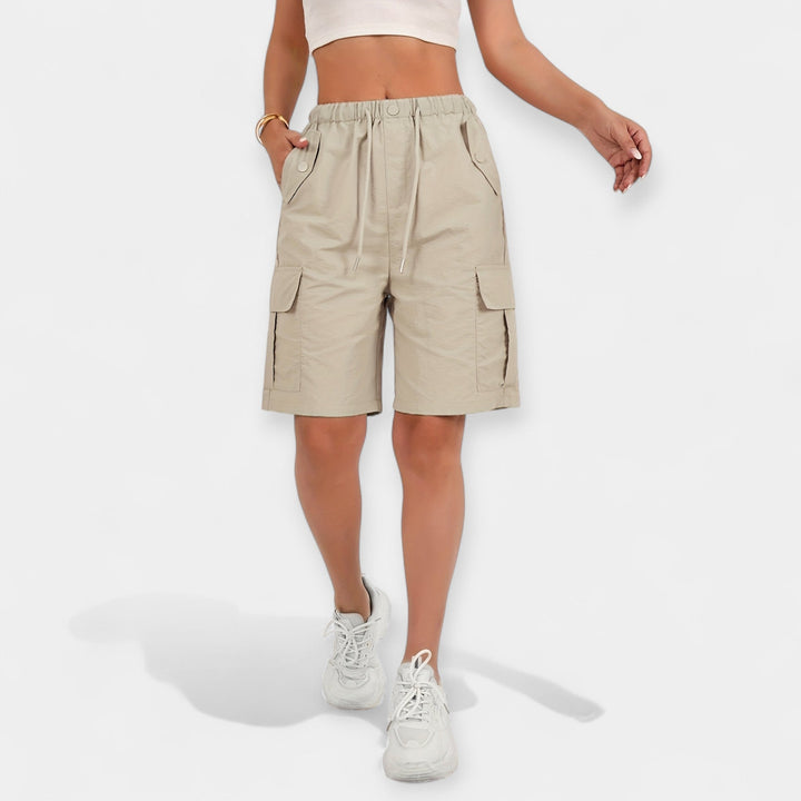 Kvinde viser komfortable dames cargo shorts; ideelle til udendørs fritid og en aktiv livsstil.