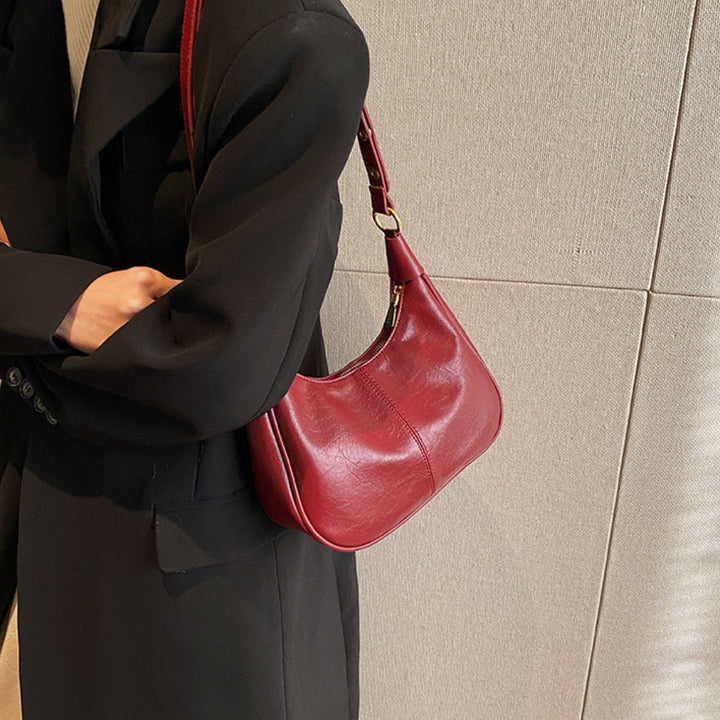 Elegant crossbodytaske med justerbar rem og guldfarvede detaljer, ideel til hverdagsbrug.