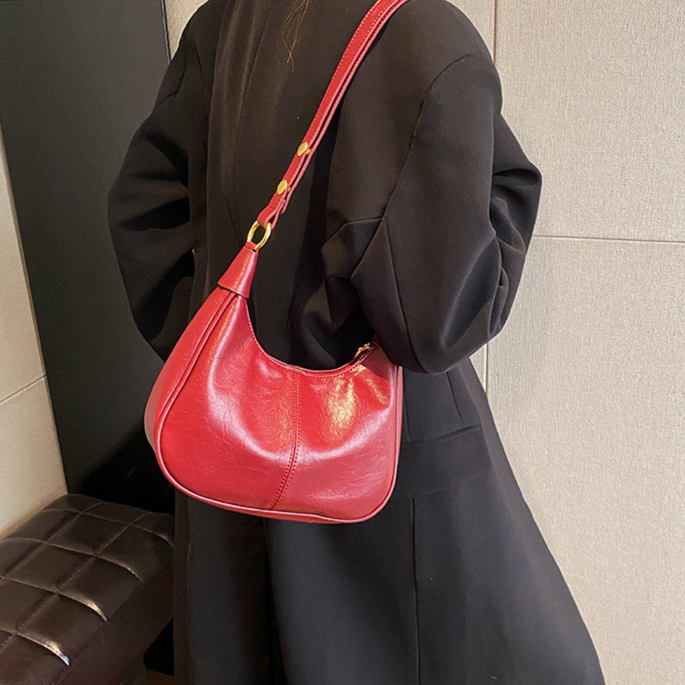 Elegant crossbodytaske med justerbar rem og guldfarvede detaljer, ideel til hverdagsbrug.