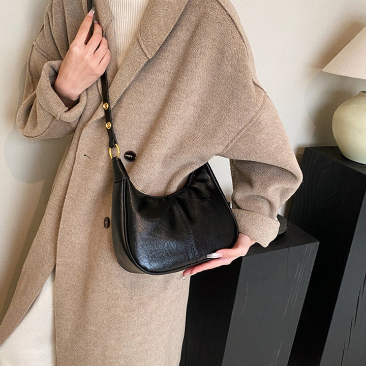 Elegant crossbodytaske med justerbar rem og guldfarvede detaljer, ideel til hverdagsbrug.