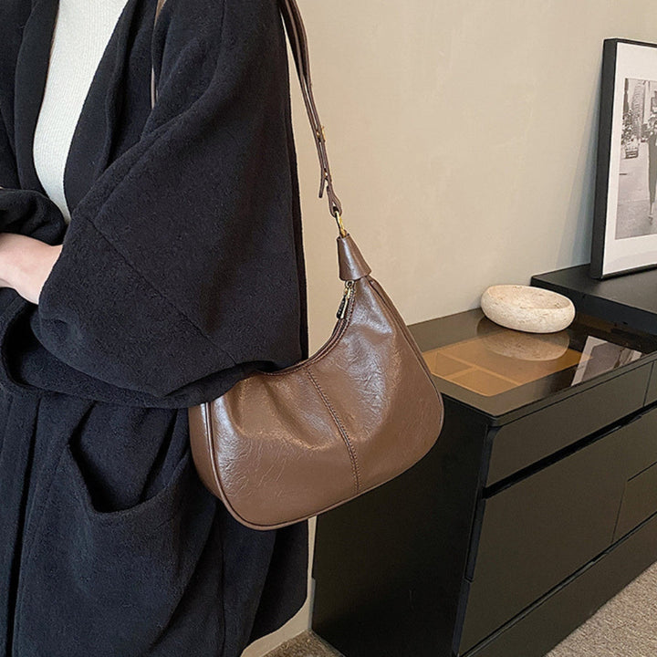 Elegant crossbodytaske med justerbar rem og guldfarvede detaljer, ideel til hverdagsbrug.