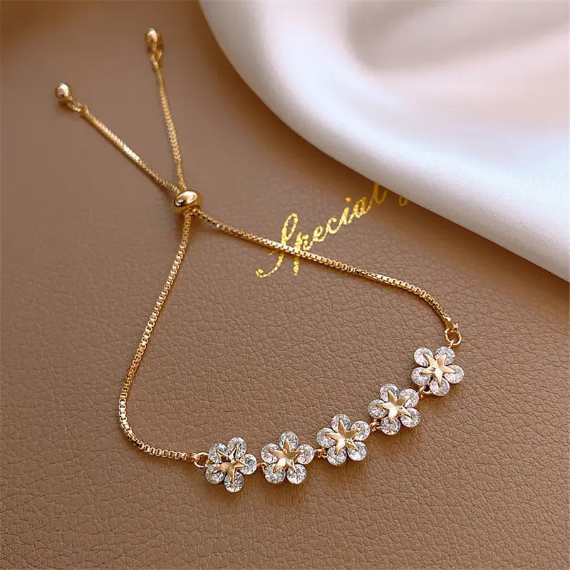 Feminint blomsterarmbånd til damer med detaljerede krystaller, et smukt smykke der skinner elegant.