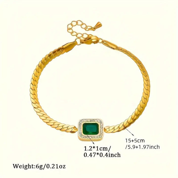 Strålende dame guld armbånd med en funklende grøn krystal. Tilføjer et elegant og luksuriøst touch til ethvert look.
