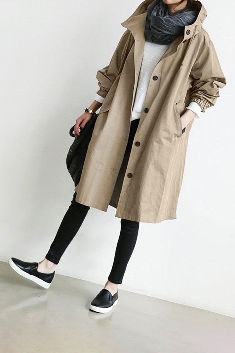 Stilfuld dame regn trenchcoat med hætte. Lang, vandtæt frakke der beskytter mod vind og regn. Klassisk look.