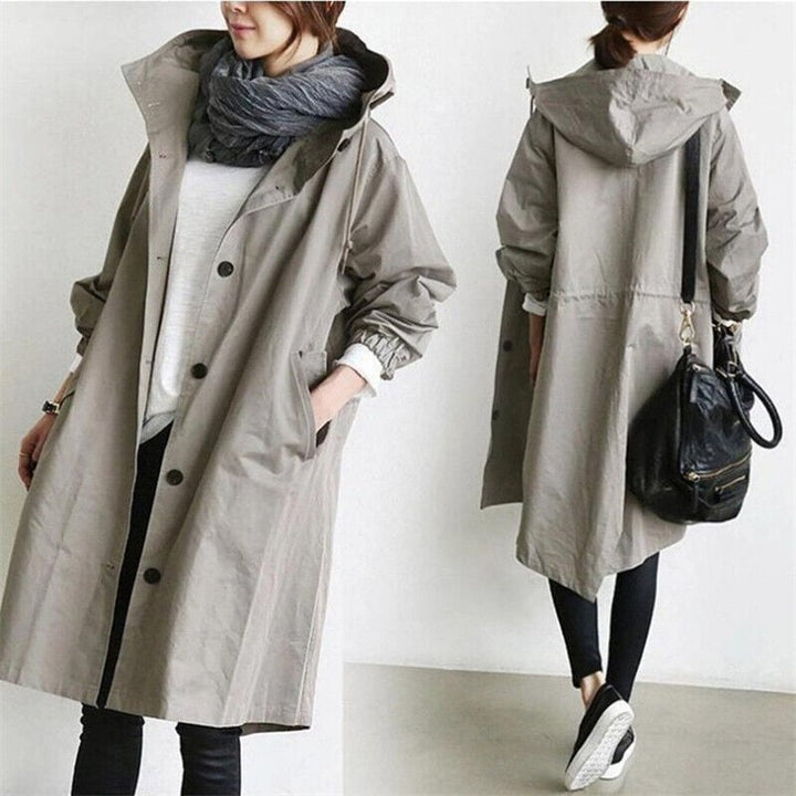 Elegant vandtæt dame regnfrakke. Klassisk trenchcoat med hætte. Optimal beskyttelse og mode til overtøj.