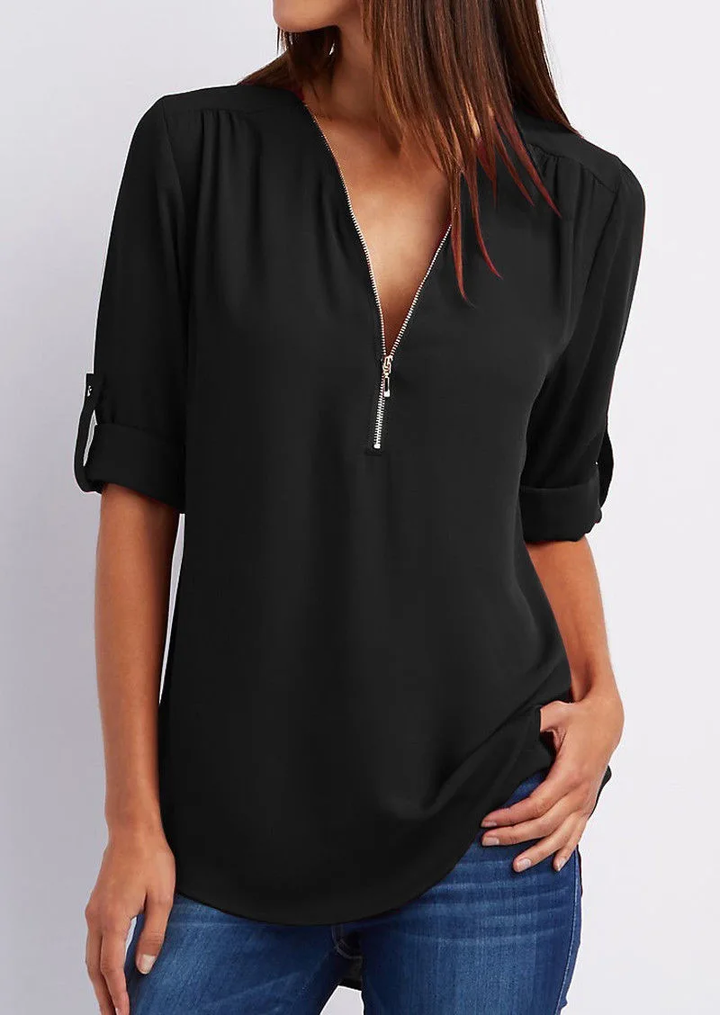 "Elegant damebluse med lynlås og blødt materiale, fås i flere farver. Perfekt til både hverdags- og festbrug."