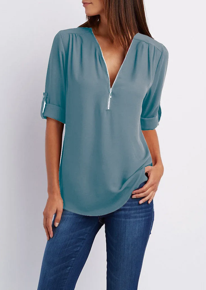 "Elegant damebluse med lynlås og blødt materiale, fås i flere farver. Perfekt til både hverdags- og festbrug."