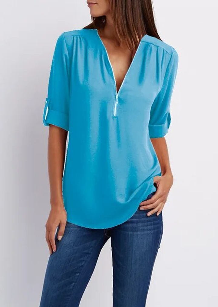 "Elegant damebluse med lynlås og blødt materiale, fås i flere farver. Perfekt til både hverdags- og festbrug."