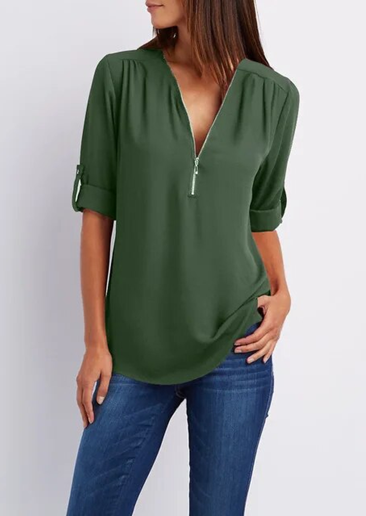"Elegant damebluse med lynlås og blødt materiale, fås i flere farver. Perfekt til både hverdags- og festbrug."