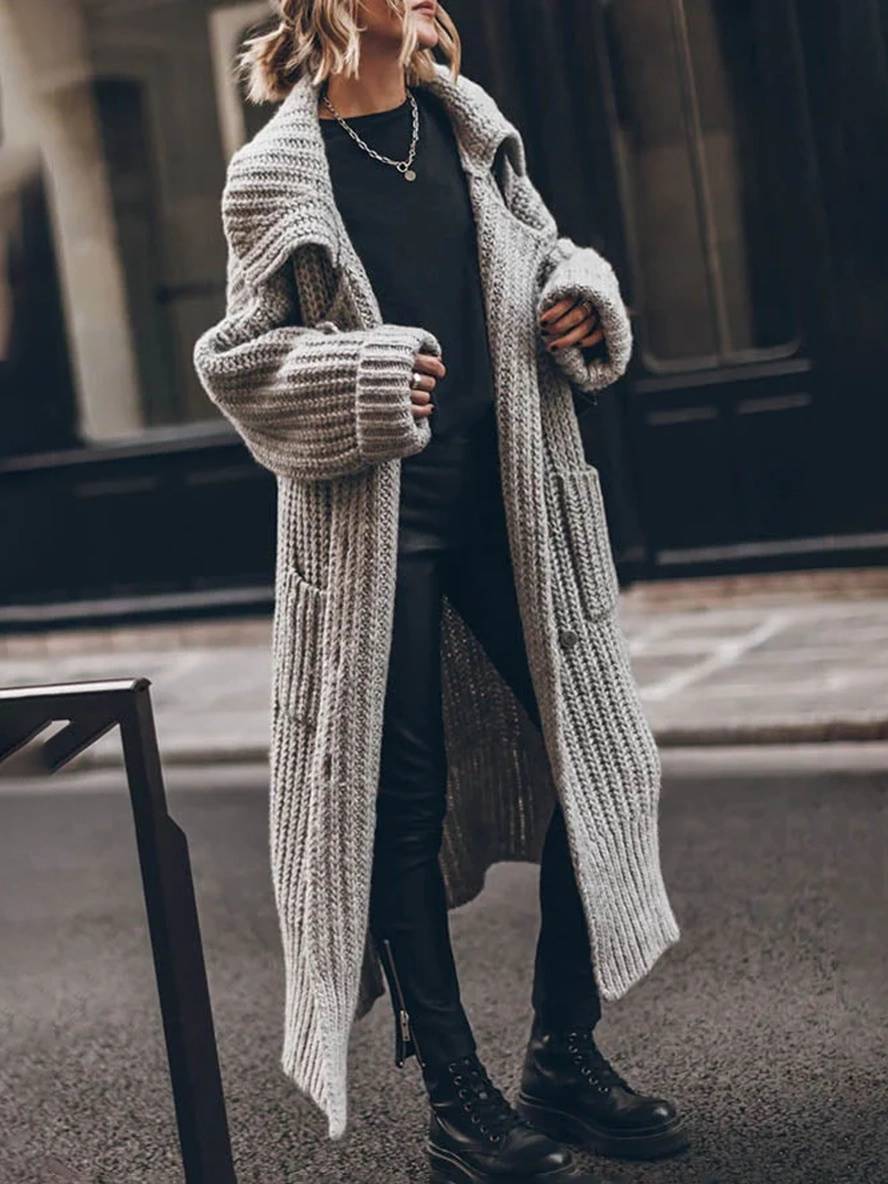 Grå oversized cardigan med knapper og reverskrave, løstsiddende og ensfarvet, til en stilfuld kvinde.