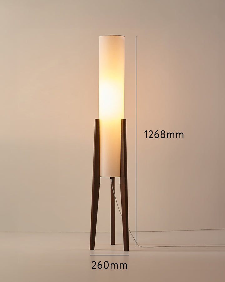 "Elegant gulvlampe i valnød med nordisk retrodesign, solid træbase og blød stofskærm, skaber hyggelig belysning."