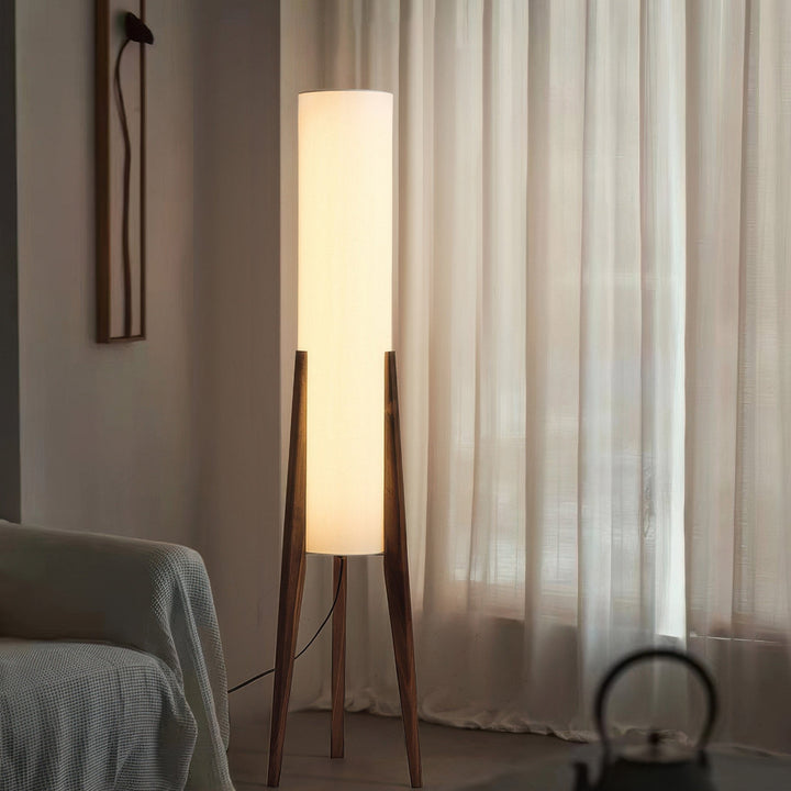 "Elegant gulvlampe i valnød med nordisk retrodesign, solid træbase og blød stofskærm, skaber hyggelig belysning."
