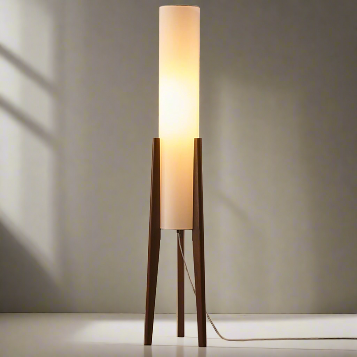 "Elegant gulvlampe i valnød med nordisk retrodesign, solid træbase og blød stofskærm, skaber hyggelig belysning."