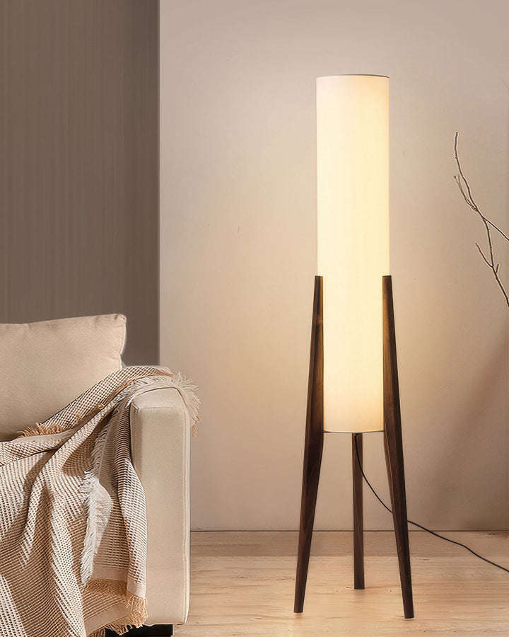 "Elegant gulvlampe i valnød med nordisk retrodesign, solid træbase og blød stofskærm, skaber hyggelig belysning."