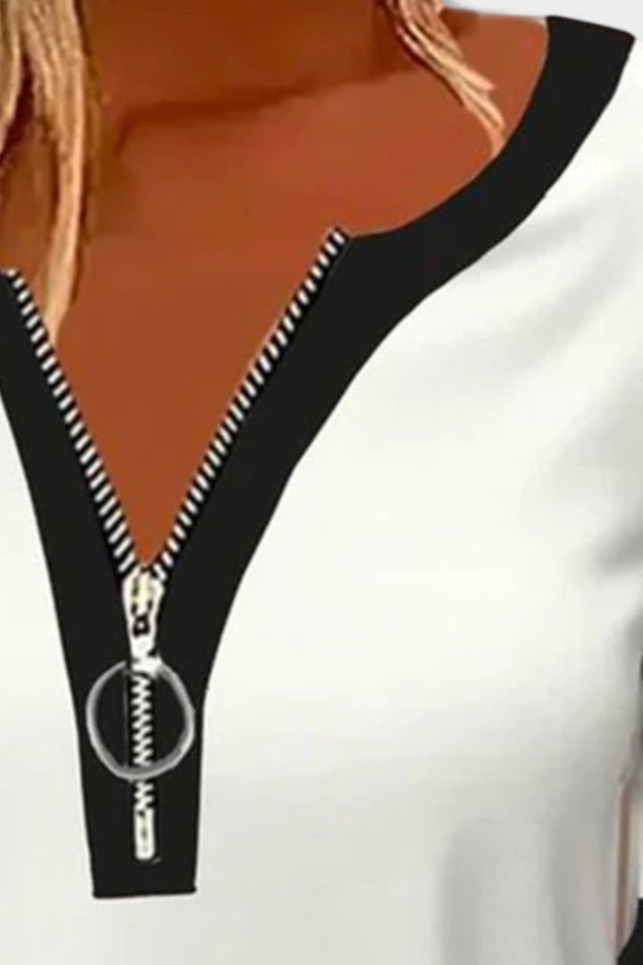 Stilfuld langærmet damebluse med lynlåskrave, hvid og alsidig, perfekt til både sporty og elegante looks.