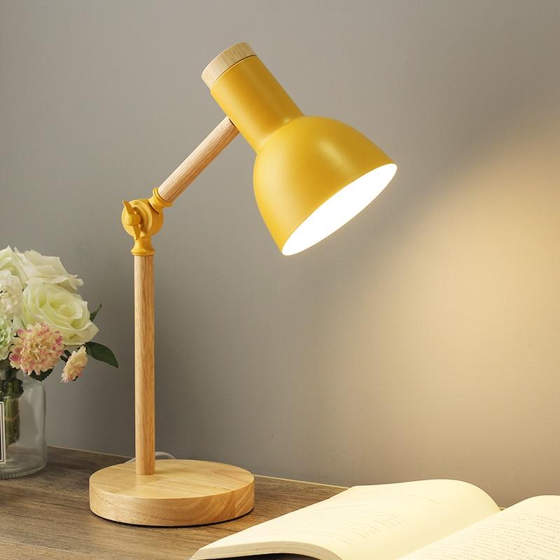 Elegant justerbar træbordlampe med foldbart design og naturlig træbase, ideel til moderne skandinavisk indretning.