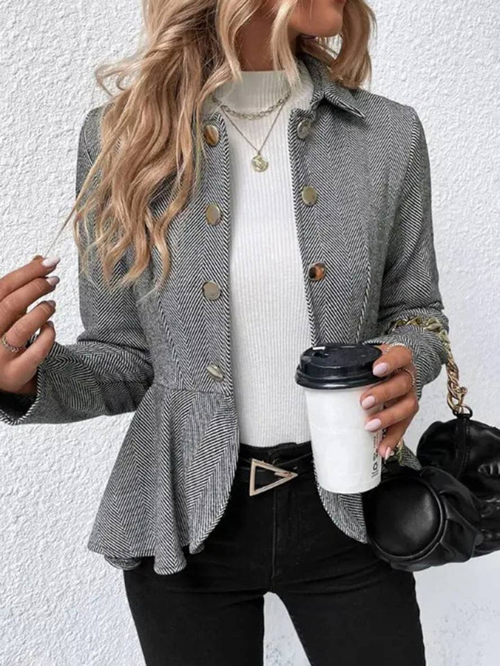 Kvindeblazer med dobbeltradet lukning, chevron-detalje og feminin peplum.