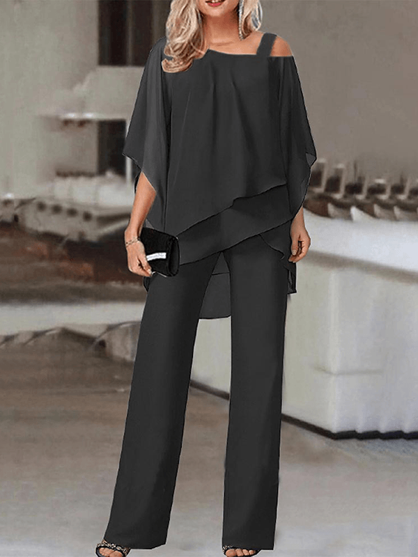 Festlig kvinde sæt med elegant asymmetrisk top og flowy vide bukser i sort. Ideelt til aftenlook og arrangementer.