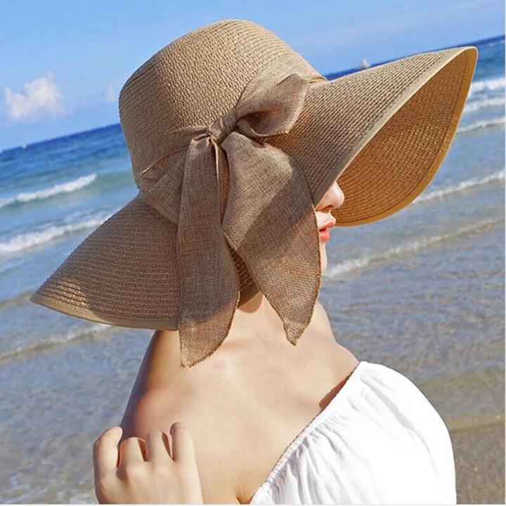 Elegant Panama hat med bred skygge, bueknude og stråmateriale. Perfekt til stilfuld solbeskyttelse på solrige dage.