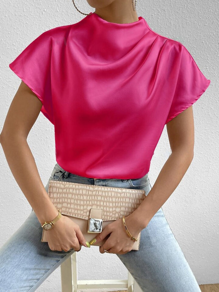 Moderne festlig damebluse med skinnende finish, høj hals og korte ærmer. Ideel til kvindemode.
