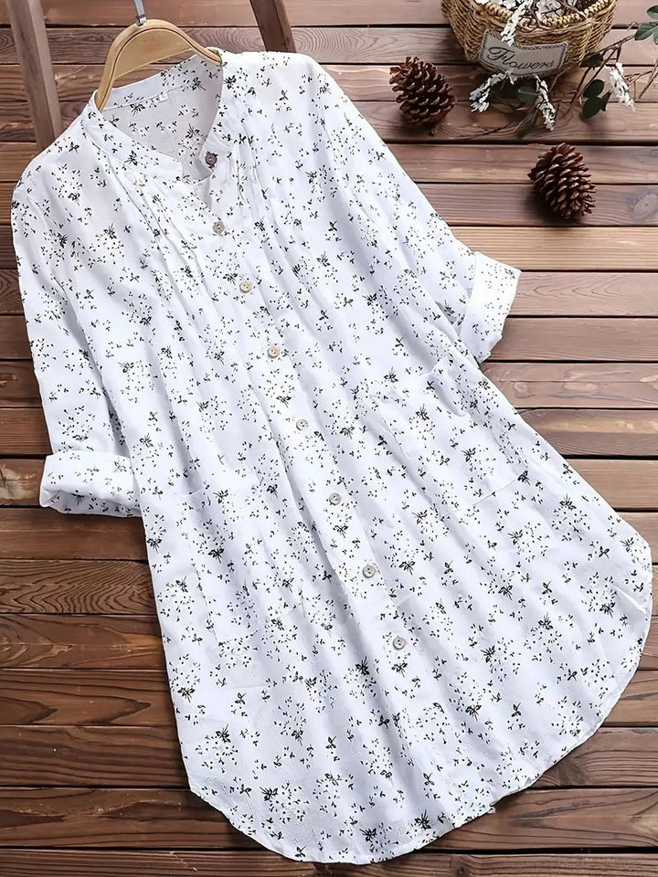 "Elegant sommerbluse i bomuld med blomstermønster, omvendt krave og løs pasform. Perfekt til feminint sommerlook."