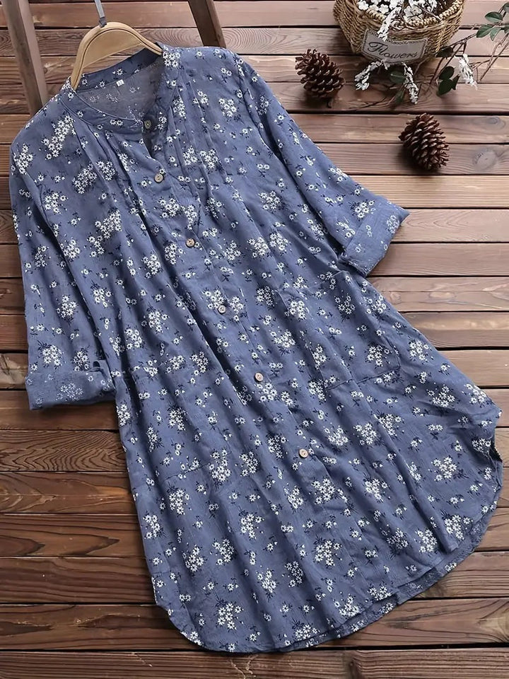 "Elegant sommerbluse i bomuld med blomstermønster, omvendt krave og løs pasform. Perfekt til feminint sommerlook."