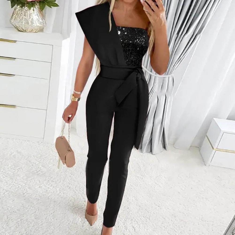 Festlig rød kvinders jumpsuit med glitrende detaljer og stilfuld one shoulder. Trendy dame mode.