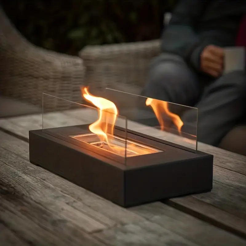 "Elegant sort bioethanol udendørspejs i rustfrit stål, dimensioner 35x18x14 cm, skaber hygge og varme i haven."