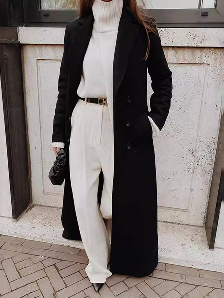 Moderne, lang sort dobbeltradet damefrakke med markante revers. Elegant og afslappet overtøj.