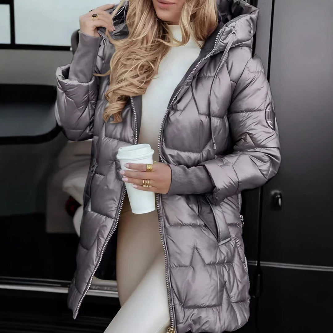 Model bærer stilfuld, quiltet dame vinterjakke med hætte. En lang og varm jakke til kvinder.