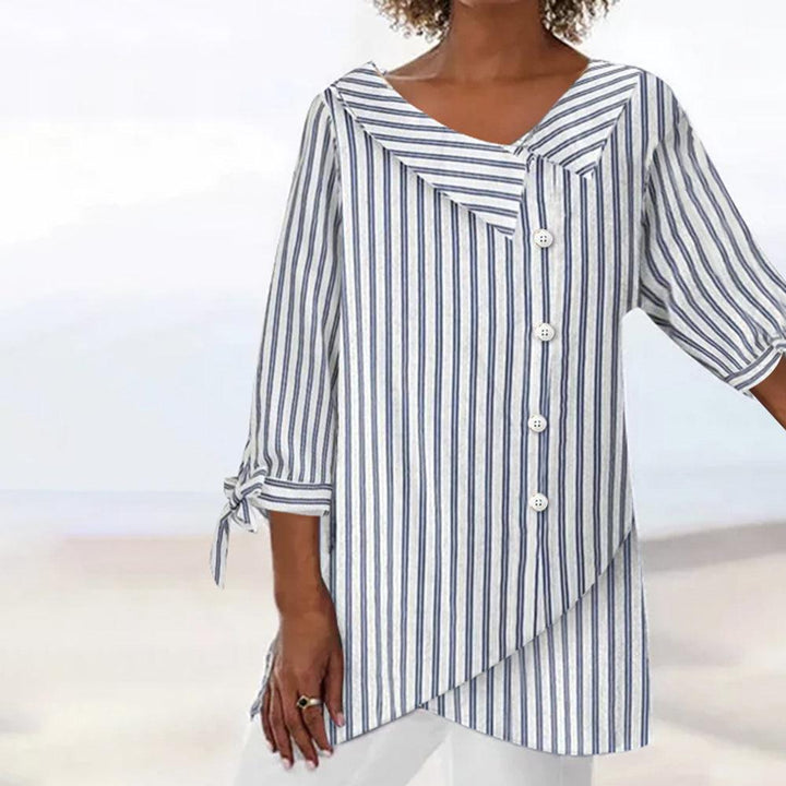 "Elegant stribet damebluse med 3/4 ærmer, frontbillede. Moderne design i komfortable, åndbare materialer."