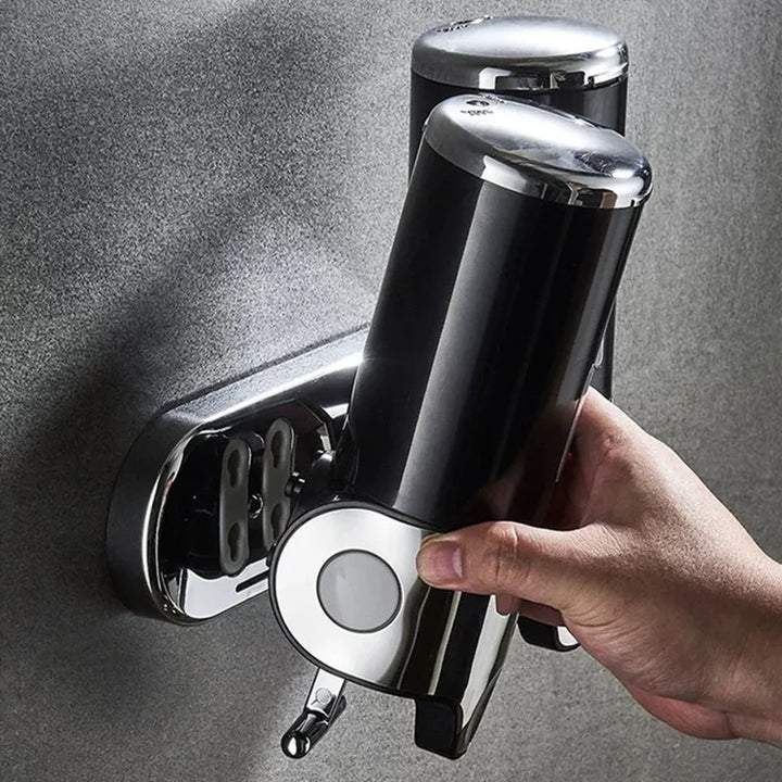 "Elegant vægmonteret sæbedispenser med dobbelt rum, minimalistisk design, gennemsigtige sektioner for nemt overblik."