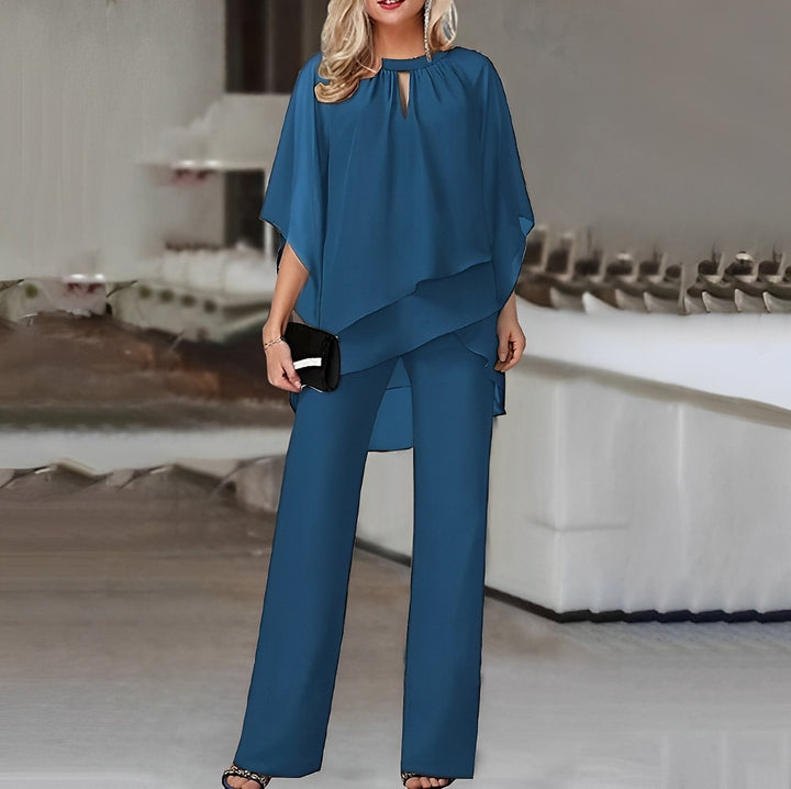 Elegant marineblå buksedragt med asymmetrisk top. Moderne festtøj til kvinder, komfortabelt og stilfuldt.
